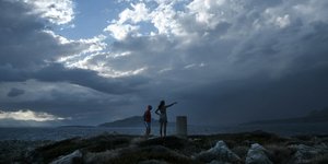 Ζευγάρι σε λόφο κάτω από τα σύννεφα