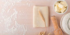 Ζύμη σφολιάτας σε αλευρωμένη επιφάνεια με βούτυρο και πλάστη