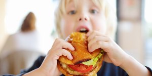 αγοράκι τρώει χάμπουργκερ