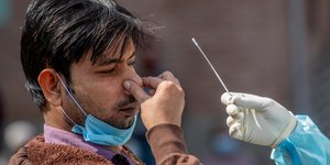 Ανδρας στην Ινδία κρατά την μύτη του ενώ υποβάλλεται σε τεστ για κορωνοϊό