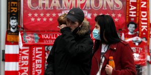 Ζευγάρι σε εξωτερικό χώρο στην Αγγλία, με μάσκες προστασίας από τον κορωνοϊό
