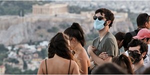 Νεαροί με μάσκες στο Λυκαβηττό με φόντο την Ακρόπολη