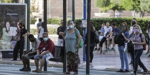 Πολίτες με μάσκα σε στάση λεωφορείου στην Αθήνα