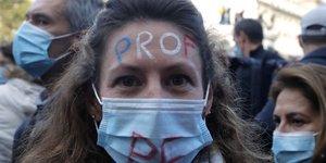 Διαδηλώτρια στη Γαλλία μετά τη δολοφονία του Γάλλου καθηγητή