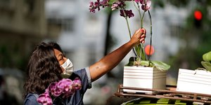 Γυναίκα τοποθετεί λουλούδια σε γλάστρα πάνω σε όχημα