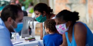 Γυναίκα στην Βραζιλία με μάσκα, κρατώντας το παιδί της