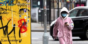 Γυναίκα με ροζ μπουρνούζι στον δρόμο