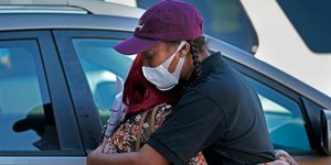 Γυναίκες αγκαλιάζονται φορώντας μάσκα