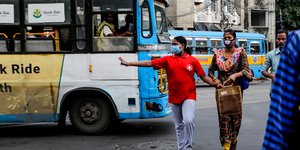 Μητέρα και κόρη με μάσκα περνάνε τον δρόμο στην Ινδία
