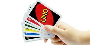Χέρι κρατά κάρτες από το επιτραπέζιο παιχνίδι UNO