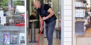 Ρύθμιση οφειλών / Ενας μαγαζάτορας καθαρίζει το κατάστημά του με σκούπα