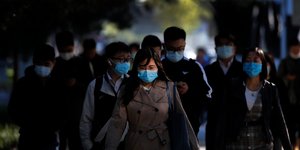 Κινέζοι περπατούν φορώντας μάσκες