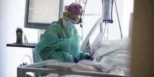 Ασθενής με κορωνοϊό σε νοσοκομείο και γιατρός με προστατευτική στολή