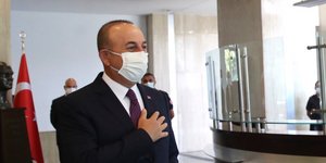 Ο υπουργός Εξωτερικών της Τουρκίας, Μεβλούτ Τσαβούσογλου με το χέρι στην καρδιά και μάσκα για τον κορωνοϊό