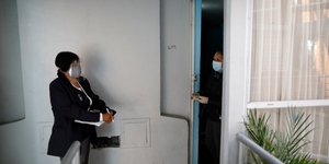 Κοινωνική λειτουργός με μάσκα επισκέπτεται σπίτι