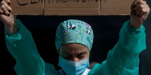 Νοσοκόμα με μάσκα και στολή διαμαρτύρεται για τις συνθήκες εργασίας εν μέσω κορωνοϊού στην Ισπανία