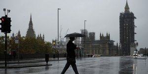 Άνδρας με ομπρέλες στο κέντρο του Λονδίνου στη Βρετανία