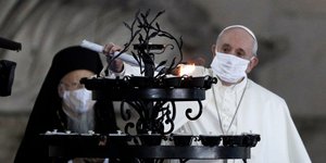 Ο Πάπας Φραγκίσκος ανάβει κερί φορώντας μάσκα υπό το βλέμμα του Βαρθολομαίου