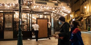 Στιγμιότυπο από το Παρίσι, ζευγάρι περπατά με μάσκες, μαγαζί κλείνει