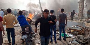 Κόσμος στην Συρία δίπλα σε συντρίμμια από αεροπορική επίθεση