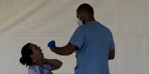 Άνδρας πραγματοποιεί τεστ για τον κορωνοϊό σε κινητή μονάδα στην Κύπρο