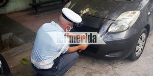 Ανδρας της Τροχαίας αφαιρεί πινακίδες από παράνομα παρκαρισμένο ΙΧ