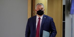 Ο Βίκτορ Ορμπαν με μάσκα κρατάει ένα ντοσιέ