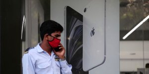 Χρήστης iPhone έξω από κατάστημα της Apple στην Ινδία