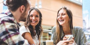 Ομάδα τριών ατόμων πίνει καφέ σε τραπέζι