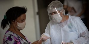 Νοσοκόμα στην Βραζιλία με μάσκα και προσωπίδα για τον κορωνοϊό