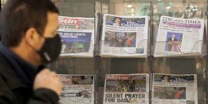 Ανδρας κοιτάζει πρωτοσέλιδα εφημερίδων για τις αμερικανικές εκλογές 2020