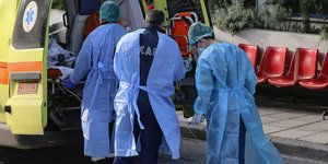 Ασθενοφόρο και νοσηλευτικό προσωπικό με προστατευτικές στολές για κορωνοϊό