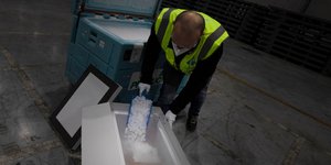 Εργαζόμενος δείχνει πώς ένα ευαίσθητο φαρμακευτικό προϊόν ή εμβόλιο διατηρείται σε χαμηλή θερμοκρασία με ξηρό πάγο, στο Swissport Pharma Center στο Machelen του Βελγίου / ΑΡ