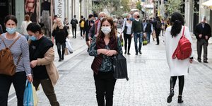 Κόσμος στην Ερμού περπατά φορώντας μάσκες