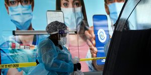 Γιατρός περπατά δίπλα από αφίσα για μάσκες