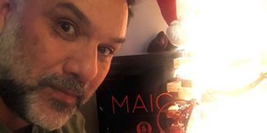 Ο Γρηγόρης Αρναούτογλου με σκούφο ποζάρει δίπλα σε χριστουγεννιάτικο δέντρο