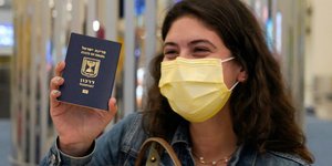 Γυναίακ με μάσκα στο αεροδρόμιο κατά το διαβατήριό της ανά χείρας
