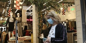Γυναίκα περνά μπροστά από βιτρίνα