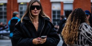 Γυναίκα με μαύρο μπουφάν και γυαλιά