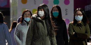 Γυναίκες στη Κίνα περπατούν φορώντας μάσκες