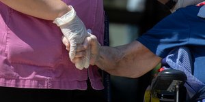 Ηλικιωμένος κρατά χέρι σε οίκο ευγηρίας