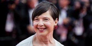 Η Ιζαμπέλα Ροσελίνι χαμογελά με κόκκινο σκουλαρίκι