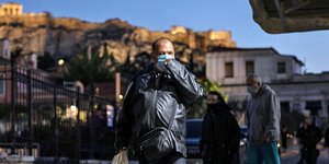 Ανδρας με μάσκα με φόντο την φωτισμένη Ακρόπολη