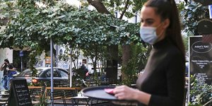 Κορωνοϊός: Μια σερβιτόρα που φορά μάσκα με τον δίσκο της