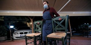 επίδομα: Μια εργαζόμενη στην εστίαση μετακινεί καρέκλες
