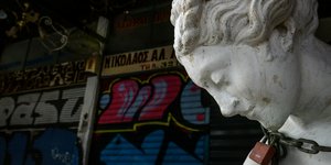 Κλειστά μαγαζιά στην Ερμού και άγαλμα με αλυσίδα