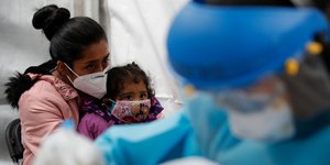 Μητέρα και παιδί με μάσκα στο Μεξικό, περιμένουν την γιατρό