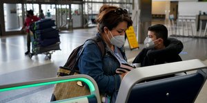 Γυναίκα με μάσκα σε αεροδρόμιο