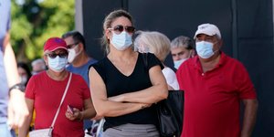 Κόσμος στέκεται στην ουρά για να ψηφίσει στις ΗΠΑ, φορώντας μάσκες