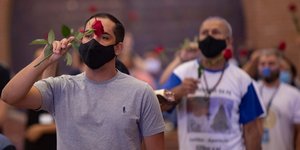 Πιστός σε εκκλησία στην Βραζιλία με μάσκα και τριαντάφυλλο